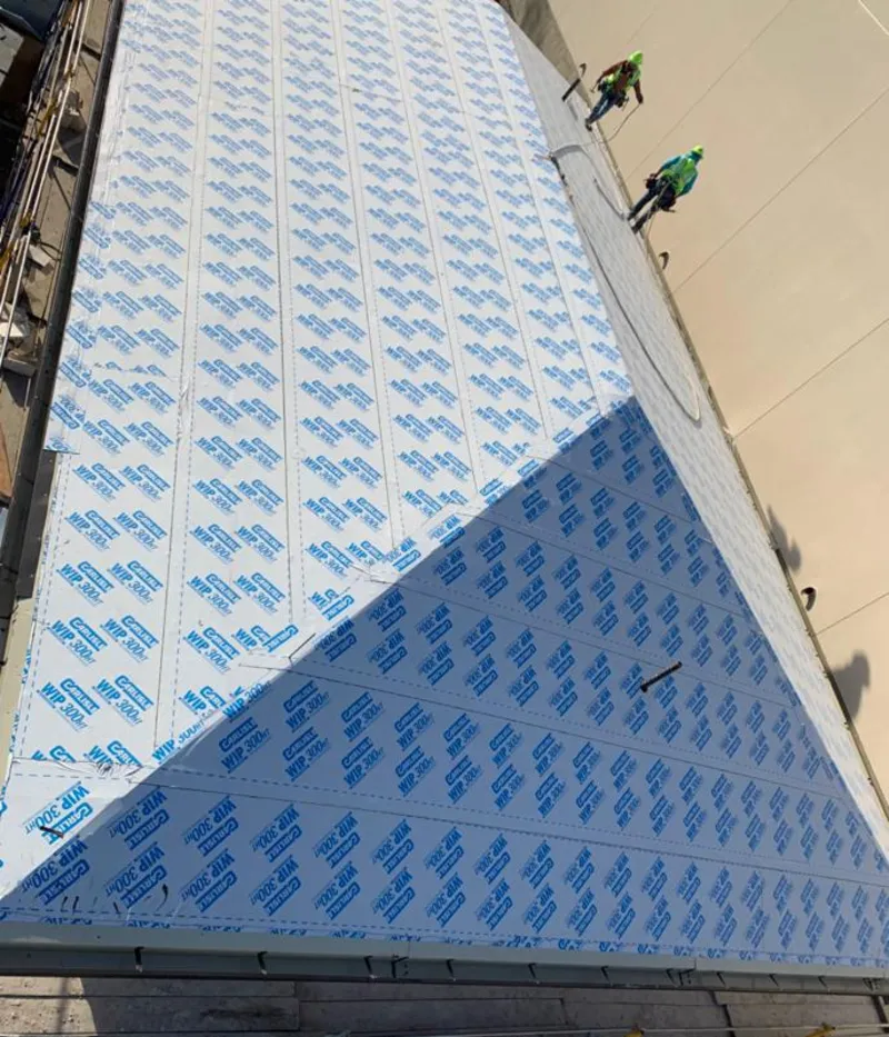 Professional roofers installing underlayment on a metal roof in Cortlandt